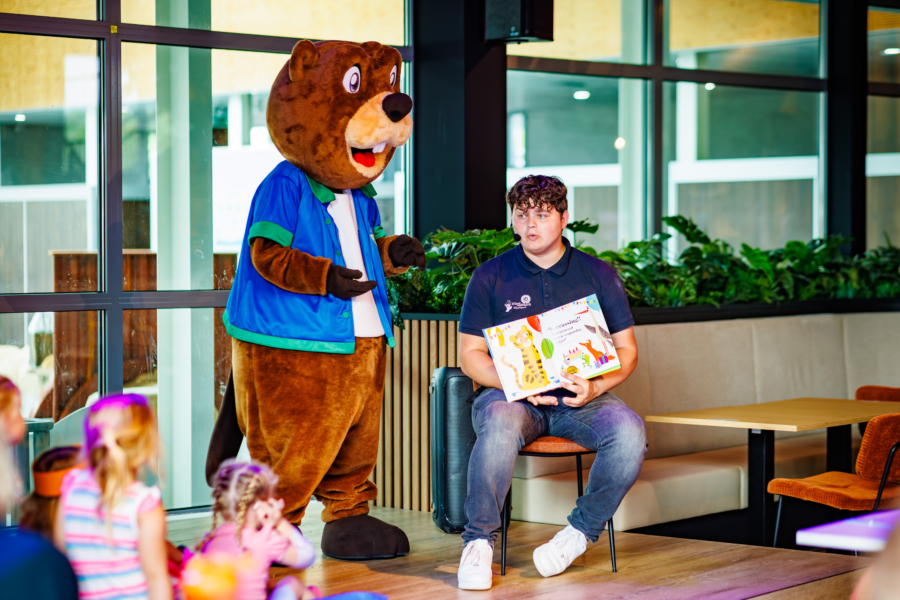 Barry de Bever leest voor aan kinderen met het animatieteam op Vakantiepark Eiland van Maurik
