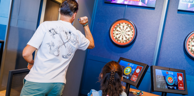 Een ouder speelt E-darten in de Sport Lounge van Mauk