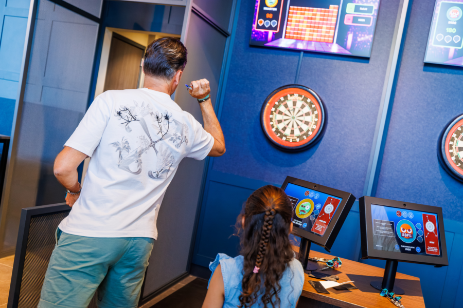 Een ouder speelt E-darten in de Sport Lounge van Mauk