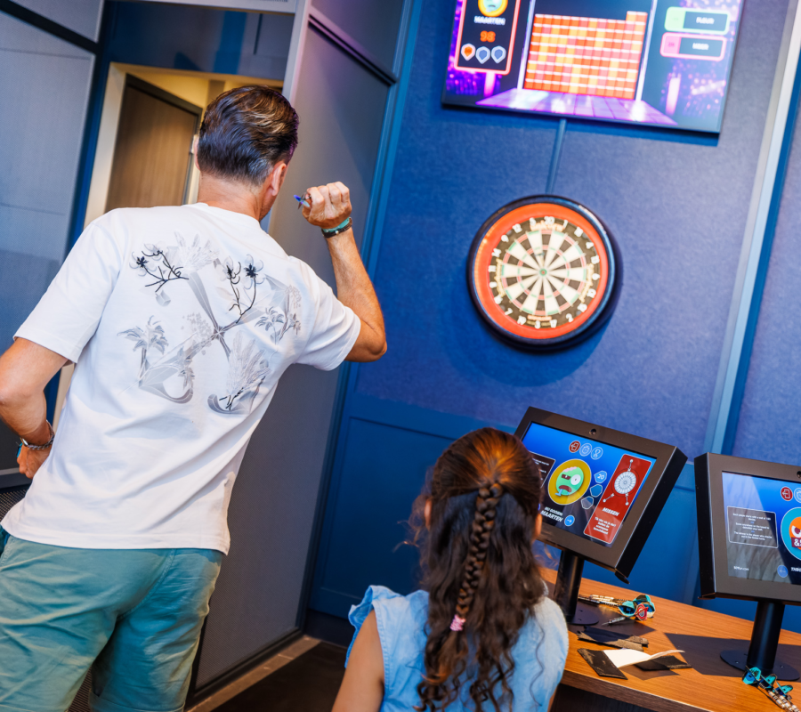 Een ouder speelt E-darten in de Sport Lounge van Mauk