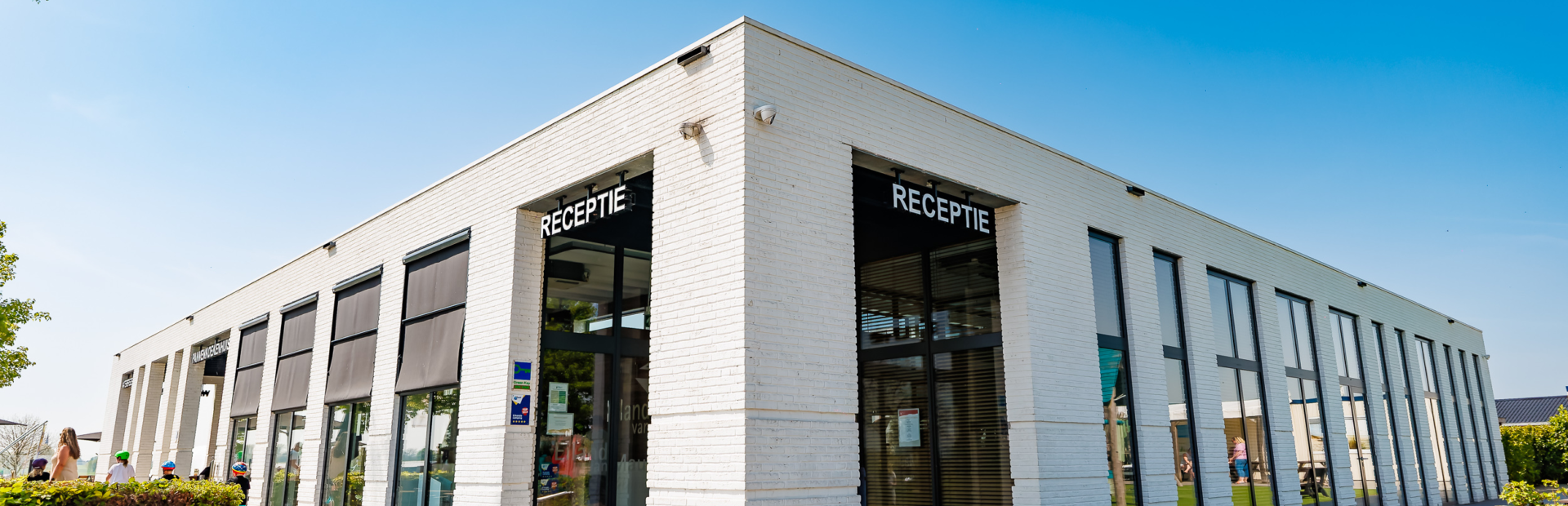 De ingang van de receptie op Vakantiepark Eiland van Maurik met blauwe lucht